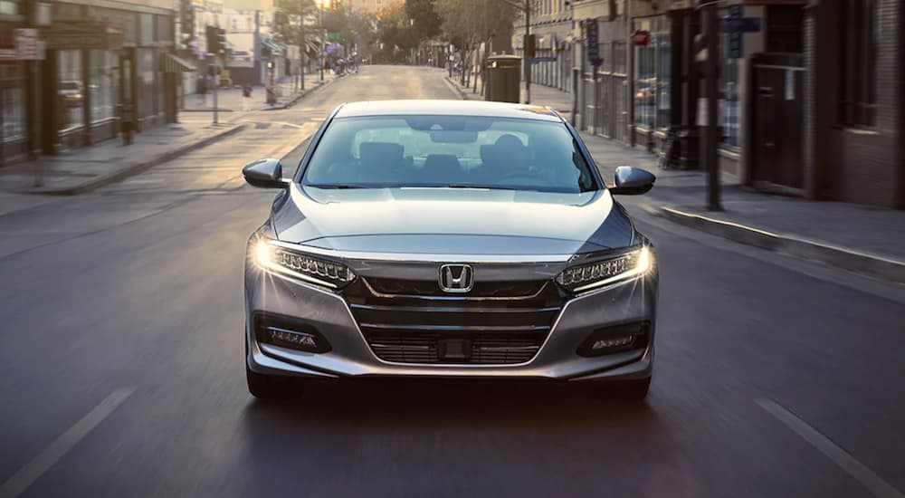 A grey 2019 Honda Accord is shown driving through a city.