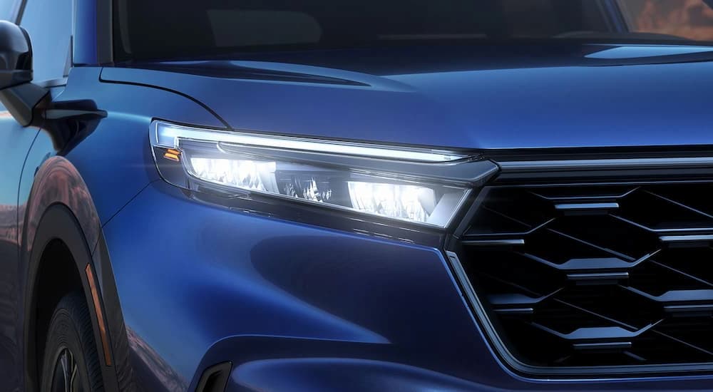A close up of the grille on a blue 2023 Honda CR-V is shown at a Honda CR-V dealer.