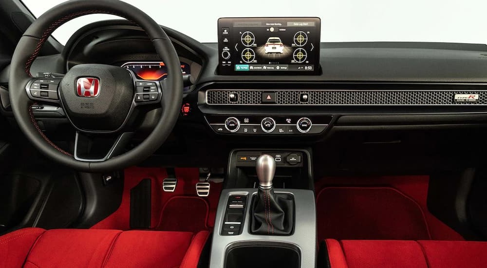 The red and black interior of a 2022 Honda Civic Type R shows the dashboard.
