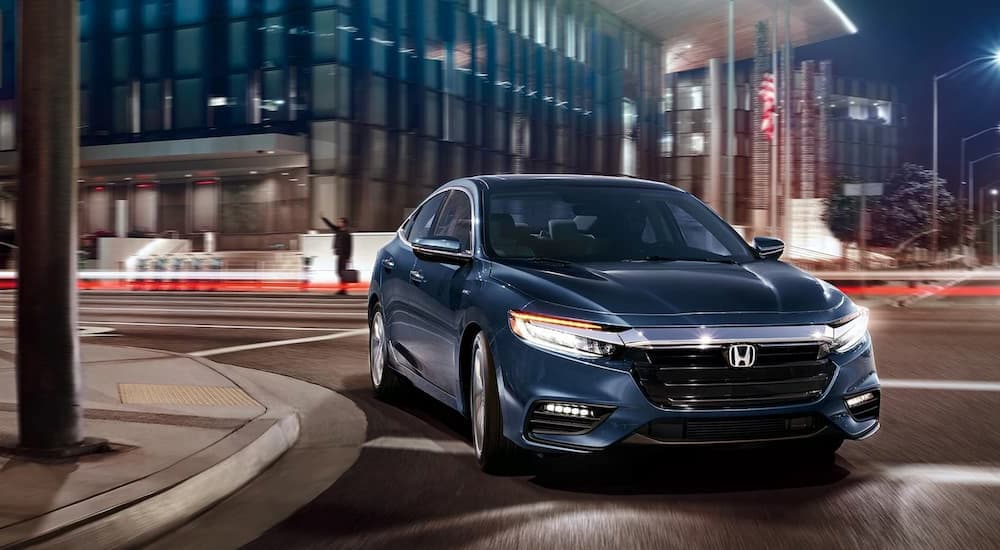 A blue 2022 Honda Insight Touring is shown leaving a Honda dealer near you.