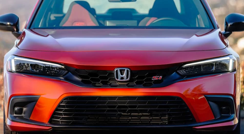 A close up shows the front of an orange 2023 Honda Civic Si is shown.