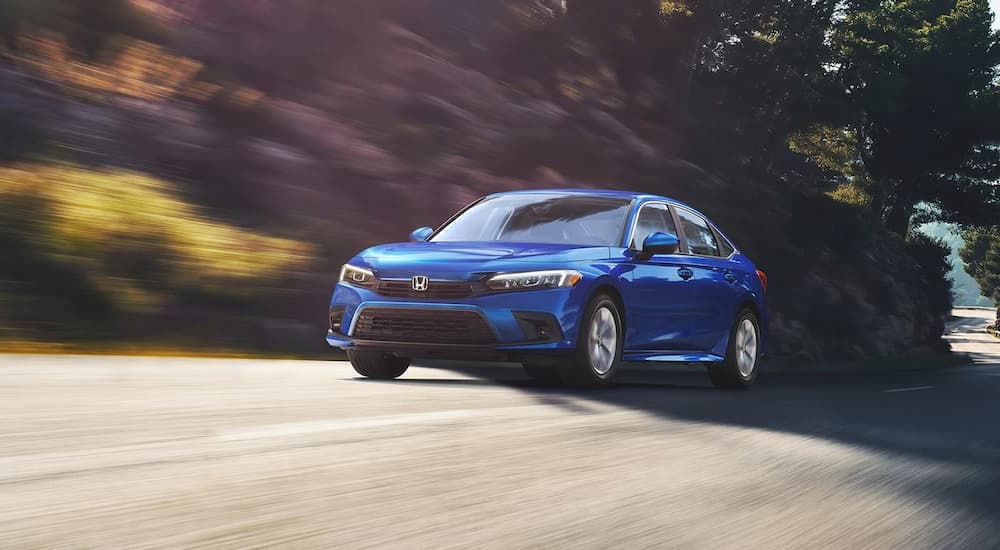 A blue 2022 Honda Civic LX is shown driving on an open road.