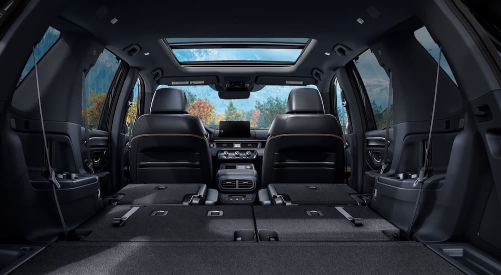 The black interior of a 2024 Honda Pilot Trailsport is shown from the rear hatch.
