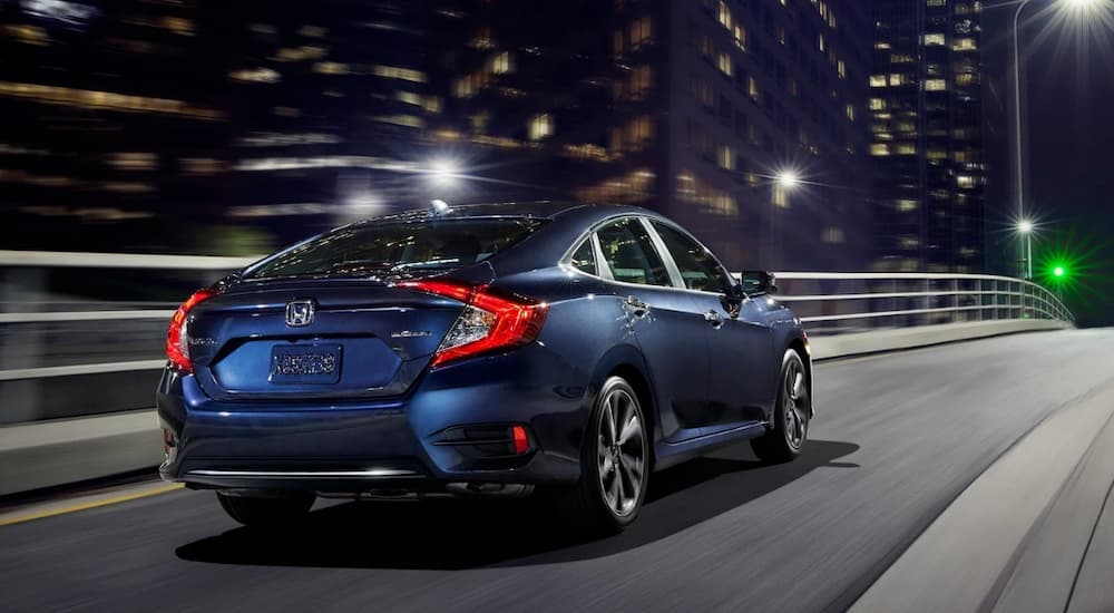 A blue 2020 Honda Civic is shown from the rear after leaving a used Honda dealership.