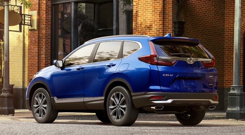 A blue 2022 Honda CR-V is shown from a rear angle parked on the side of a city street.