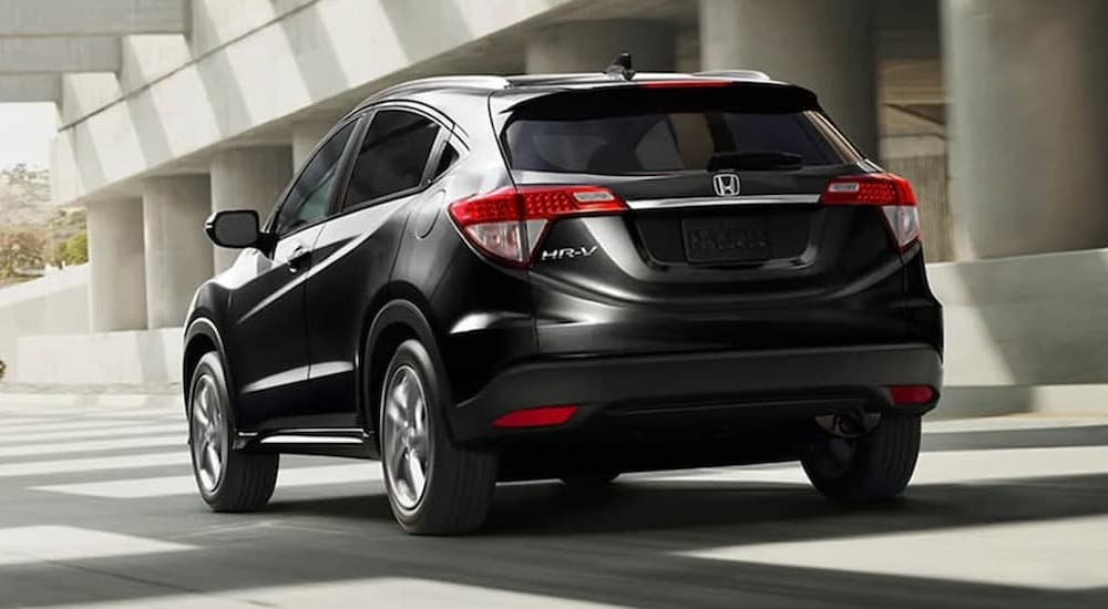 A black 2020 Honda HR-V EX-L is shown from the rear driving under a bridge after viewing used cars for sale.