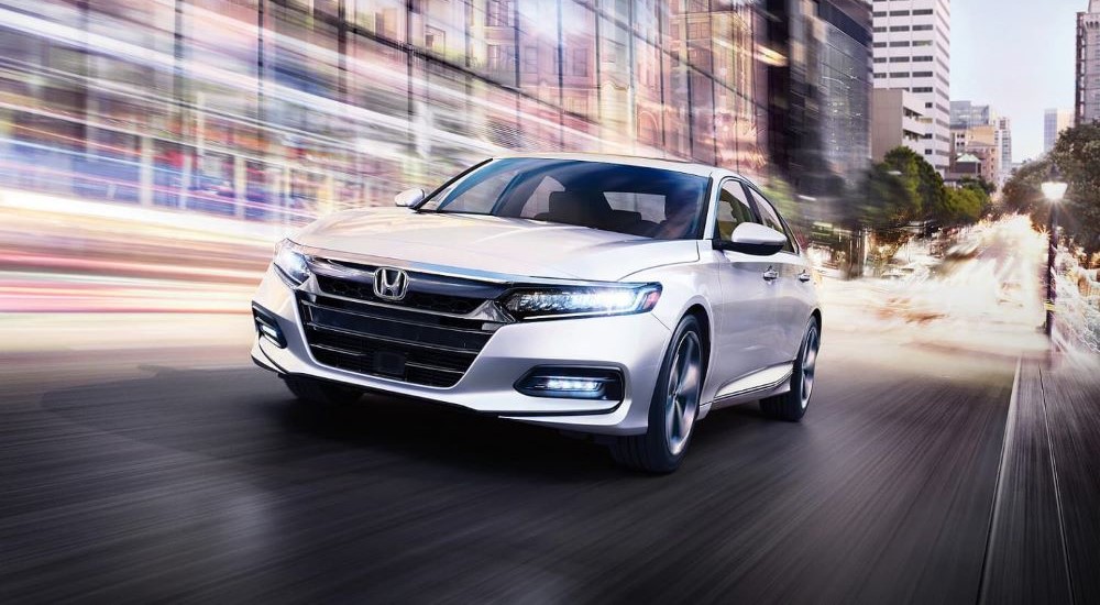 A white 2020 Honda Accord Touring is shown driving.